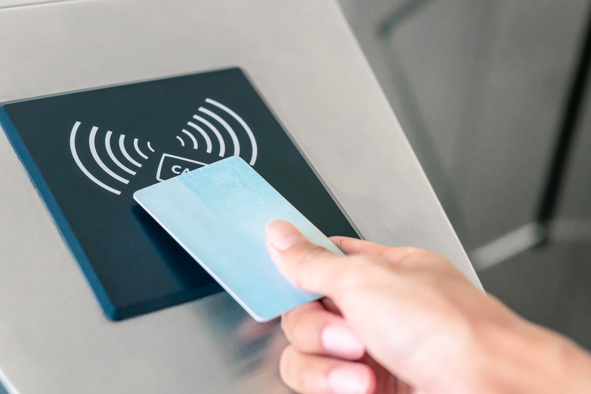 Hand holding Blue Card to access Electronic Entrance Scanner,